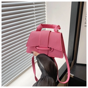 Detail of pink lychee textured leather mini square bag with pleated handle and strap