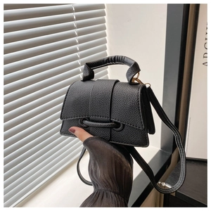 Detail view of the black lychee pattern leather mini handbag with top handle and strap