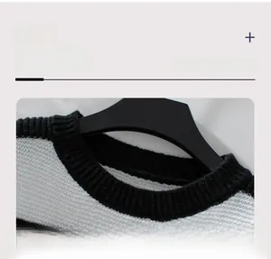 Detail of the black ribbed crew neck and striped knitting texture of the sweater