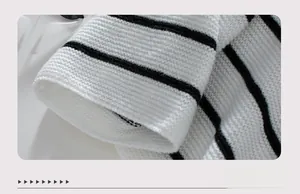 Detail of the high-quality cuff on a loose black and white striped knitted sweater