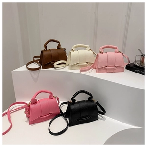 Detail of five mini crossbody bags with litchi texture on minimalist white display stands