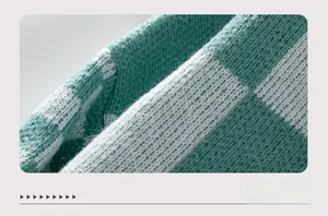 Close-up of green and white checkered knit fabric texture for winter sweaters