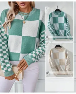 Detail of color-block checkered knit sweater featuring ribbed cuffs and crew neck finish
