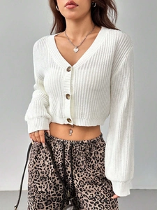 Short white V-neck knitted cardigan with amber buttons for a stylish winter look