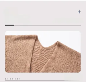Detail view of the V-neckline with ribbed knit texture on coffee-colored tassel poncho