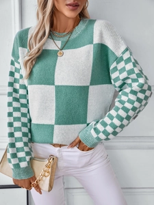 Close-up of green and white checkerboard knit sweater with textured plaid pattern