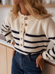 Detail of waffle texture and dark brown buttons on cream striped knit cardigan