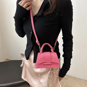 Pink minimalist crossbody bag with textured leather and iconic large handle on model