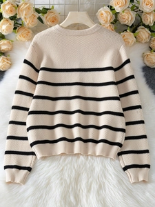 Detail of waffle texture and striped pattern on long sleeve knit sweater for women