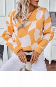 Detail showing high-quality orange and white geometric knit texture with rolled cuffs