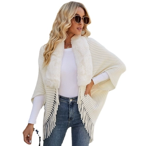 Elegant white knit poncho featuring a plush faux fur collar and stylish fringe hem detailing