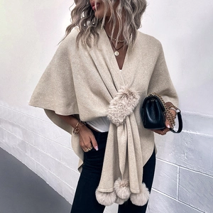 Elegant beige knit poncho sweater with faux fur trim and pom-pom details for women