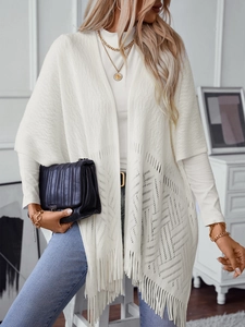 White knit poncho with fringe hem and geometric openwork, stylish winter shawl for women