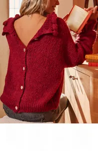 Detail view of red knit cardigan featuring ruffle trim and unique back button closure design