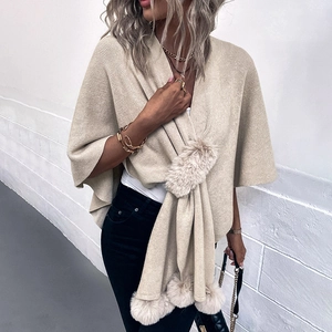 Elegant beige knit shawl poncho with faux fur trim and pom-poms for autumn fashion