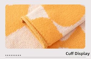 Close-up of ribbed cuffs on a contrast color knit sweater with orange cloud pattern