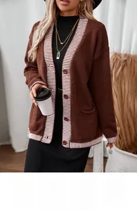 Detail of dark brown knit cardigan featuring white striped trim and textured fabric