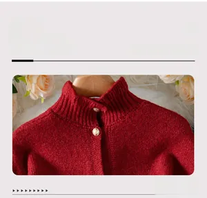 Macro view of red knit cardigan featuring high neck with embossed gold buttons