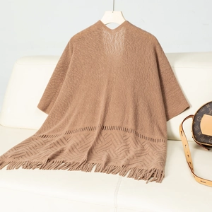 Detail of hollow geometric knit pattern and long fringe tassels on a khaki shawl