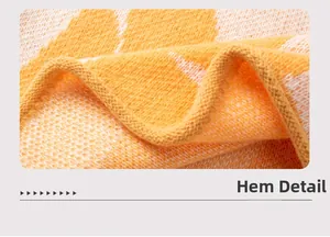 Detail of orange and white jacquard knit hemline with thick textured fabric