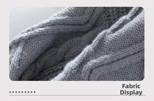 Close-up of gray cable knit fabric showing high-quality texture and braided wool pattern