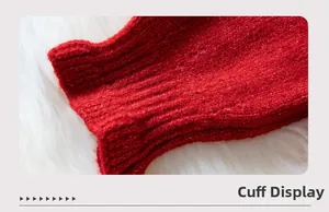 Detail of red knit sweater sleeve showing textured rib-knit cuff on plush background