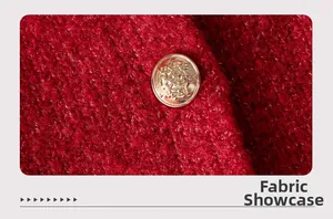 Macro close-up of dark red textured tweed fabric with an embossed gold metal button
