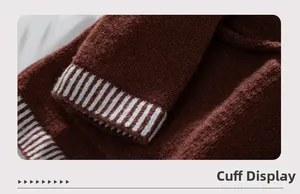 Close-up of brown knit sweater cuff featuring ribbed texture and white stripe detail
