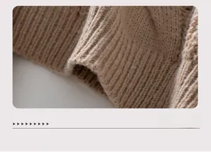 Close-up of cable knit texture and ribbed hem on a loose khaki pullover sweater