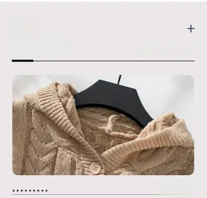Close-up of beige thick knit hoodie with chunky cable pattern and button detail