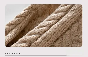 Detailed view of khaki cable knit texture and ribbed cuff on a thick winter sweater