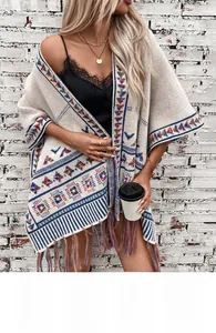 Details des Boho-Strickschals mit geometrischen Mustern und bunten Quasten am Saum