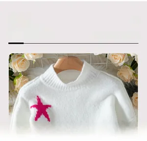Detail of soft white knit sweater neckline featuring a vibrant pink star pattern