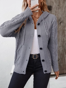 Detail of grey cable knit hooded cardigan featuring black buttons and thick texture