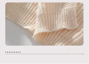 Detailed close-up of the ribbed hem on a beige oversized knit cardigan sweater