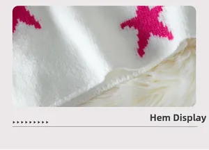 Close-up of knit sweater hem with vibrant pink star pattern and soft texture