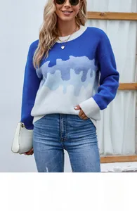 Close-up of color-blocked knit sweater with blue and white wave patterns and ribbing detail