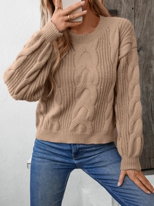 Detail of khaki cable knit sweater showing retro texture and round neck design