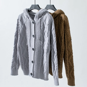 Detail of chunky cable knit texture on hooded cardigans in grey and brown colors