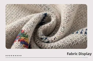 Nahaufnahme der Strickdetails mit Jacquardmuster und weicher Textur am Poncho