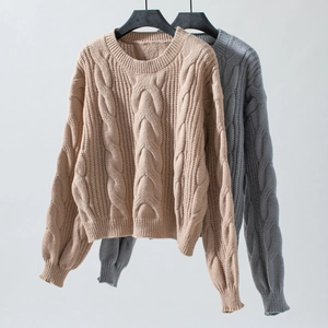 Detailed cable knit pattern on loose crewneck sweaters in beige and grey colors