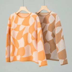Detail of color-block knit sweaters with geometric patterns and ribbed crewneck design