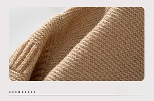 Detailed close-up of soft beige knit fabric showing fine texture and ribbed cuff detail
