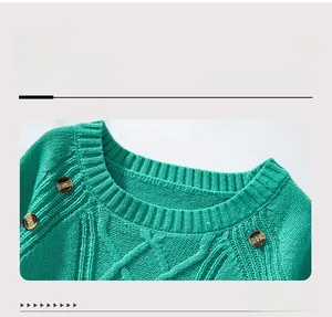 Detail of green cable knit sweater featuring a ribbed crew neck and decorative wooden buttons