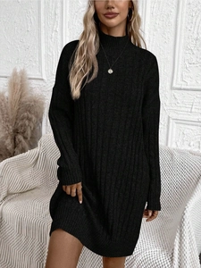 Détail de la robe noire en maille à col roulé montrant la texture côtelée et le tissu premium