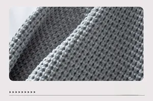 Makroaufnahme der grauen Grobstrick-Stoffstruktur mit quadratischem Muster der Strickjacke