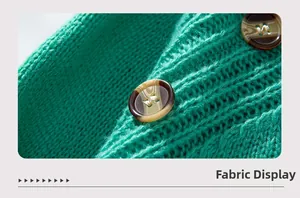 Macro detail of grass green ribbed knit sweater with textured amber resin buttons