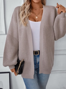 Detail of oatmeal knit cardigan showing chunky ribbed texture and lantern sleeve style