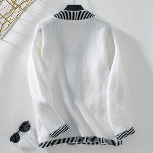 Detail of white knit cardigan showing striped trim and fluffy textured wool material
