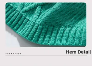 Close-up of emerald green knit sweater showing diamond cable knit and ribbed hem details